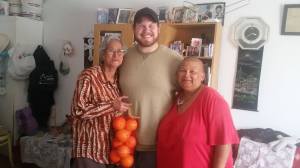 Evan with Auntie Tina (holding oranges) and Auntie Lorna, members of his community